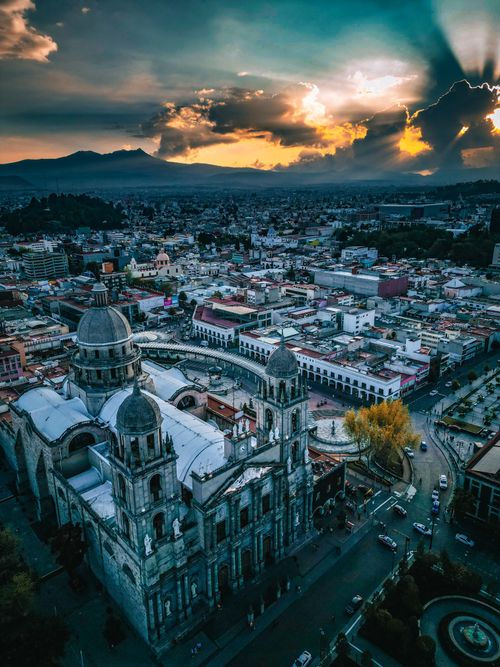 Free A breathtaking aerial view of Toluca with the iconic cathedral at sunset, showcasing vibrant cityscape and dramatic skies. Stock Photo