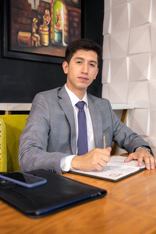 Businessman in Suit Sitting by Table