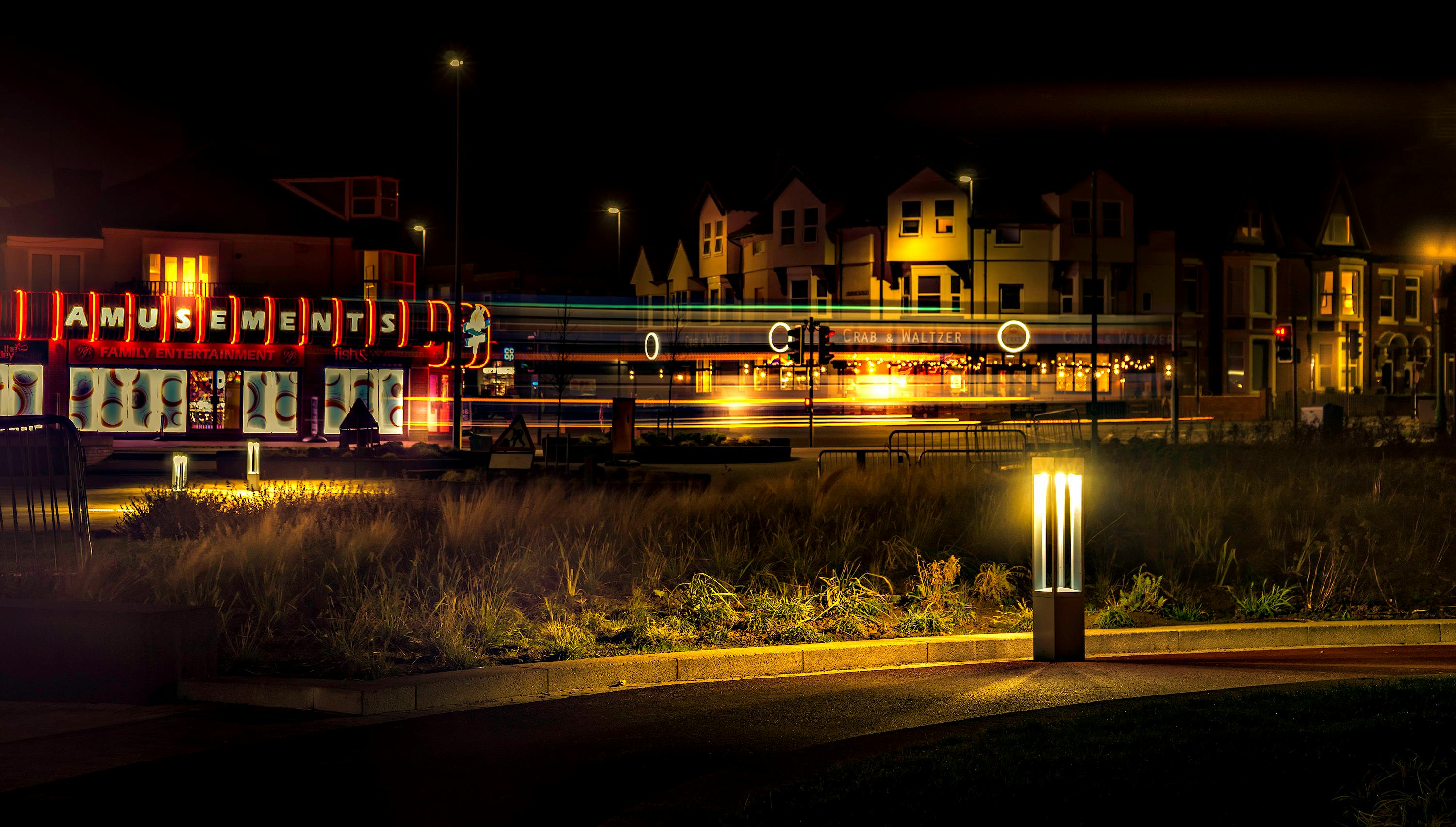 在长时间曝光下，明亮的游乐园灯光为充满活力的城市夜色增添了光彩