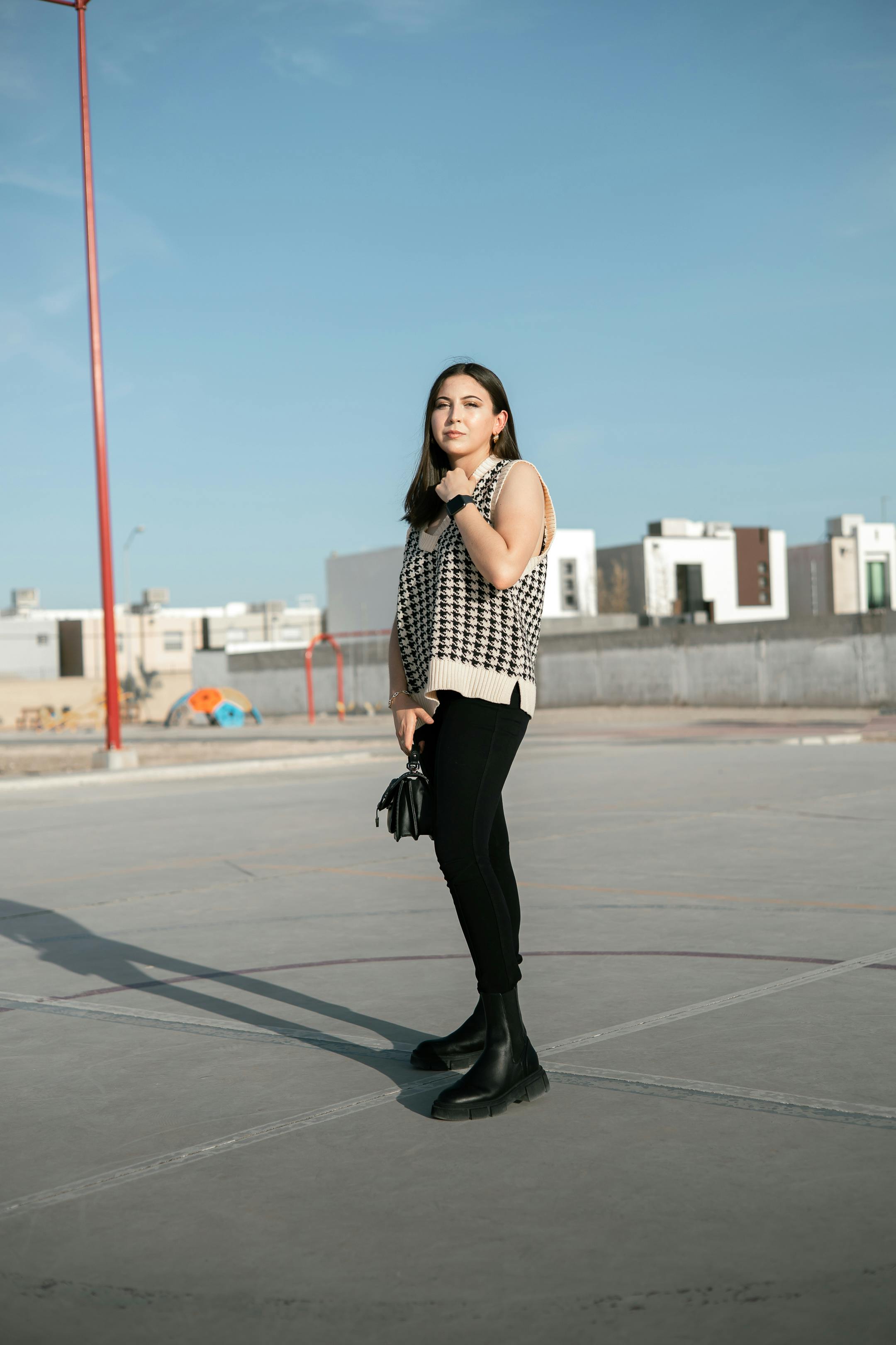 a woman standing on a basketball court wearing black pants