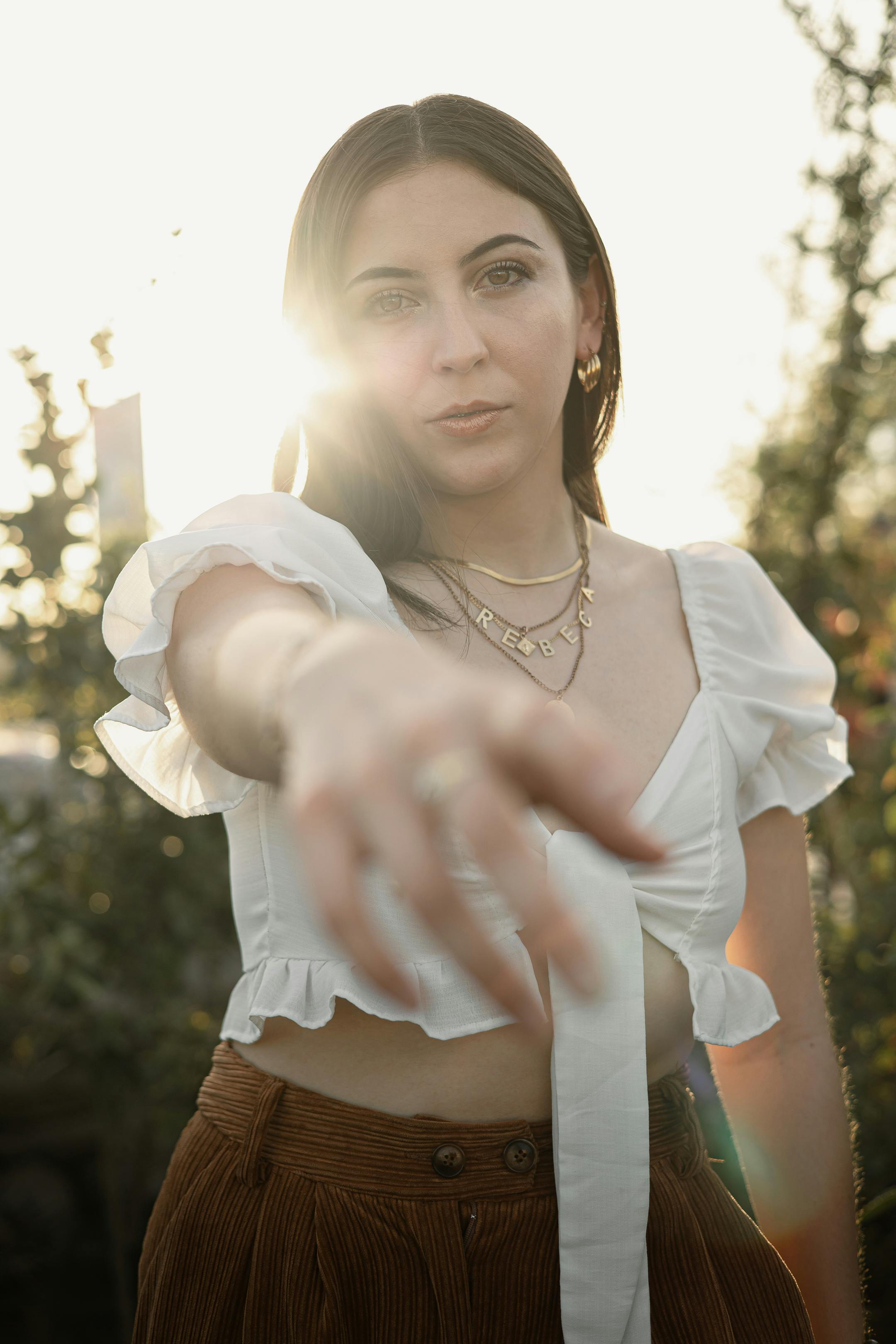 a woman in a white top and brown skirt pointing at something