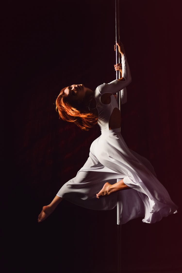 Woman In White Dress Hanging On Pole