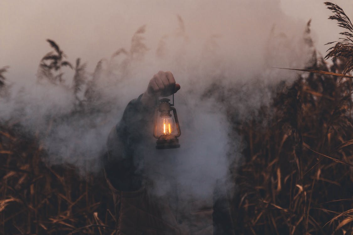 Person Holding Kerosene Lantern