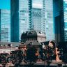 The historic brick facade of Tokyo Station stands in sharp contrast to the towering modern glass skyscrapers of the Marunouchi financial district.