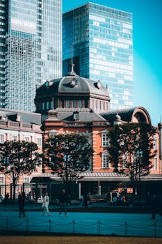 Stunning view of Tokyo Station's iconic architecture amidst towering skyscrapers during the day.