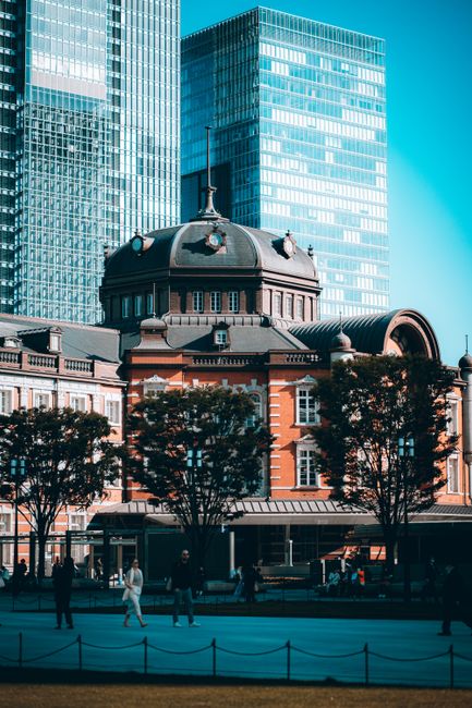 Stunning view of Tokyo Station's iconic architecture amidst towering skyscrapers during the day.