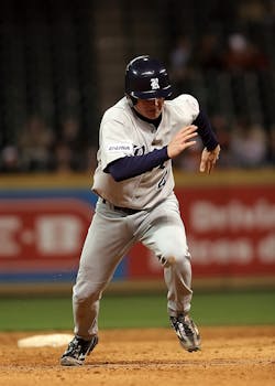 A baseball player in motion on the field, showcasing athleticism during a night game.