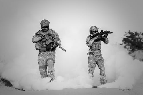 бесплатная Двое мужчин в военной одежде с оружием Стоковое фото