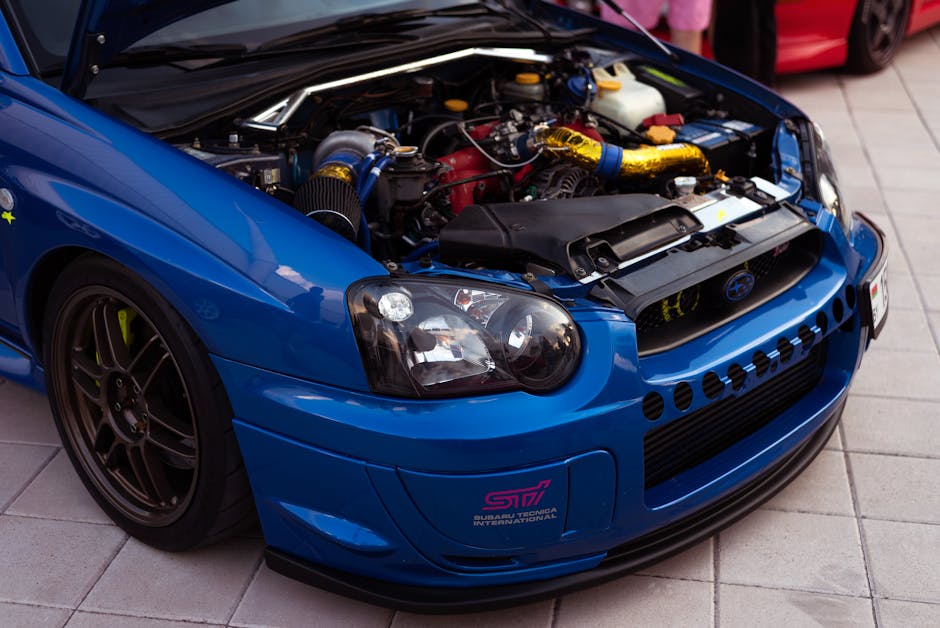 Close-up of a Subaru Impreza sports car engine in a vibrant blue livery, showcasing performance parts.