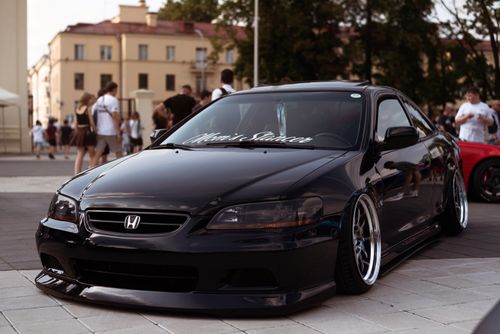 Free Black Honda Accord showcased in a lively town setting with people in the background. Stock Photo