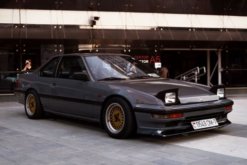 Free A vintage Honda Prelude parked in an urban area, perfect for auto enthusiasts. Stock Photo