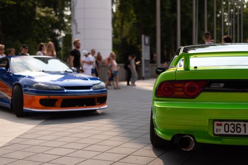 Free Colorful cars displayed outdoors with a crowd at a car show. Stock Photo