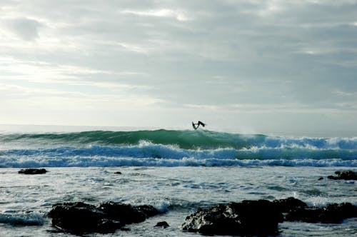 Person on Board Surfing on Wave in Ocean