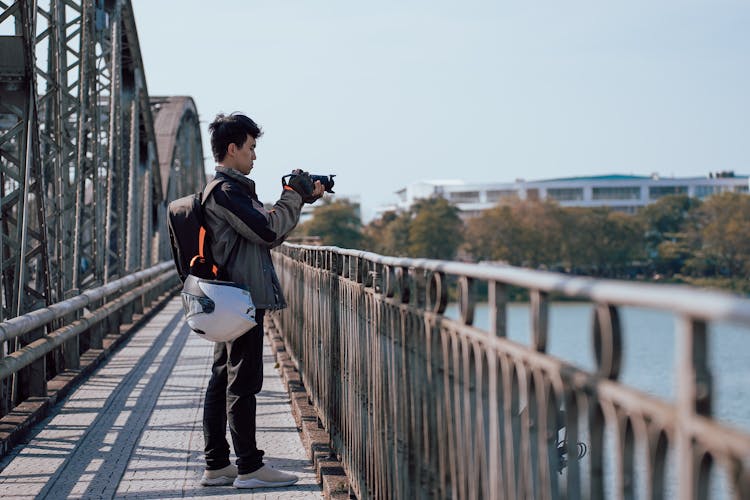 Man With Professional Camera On Bridge