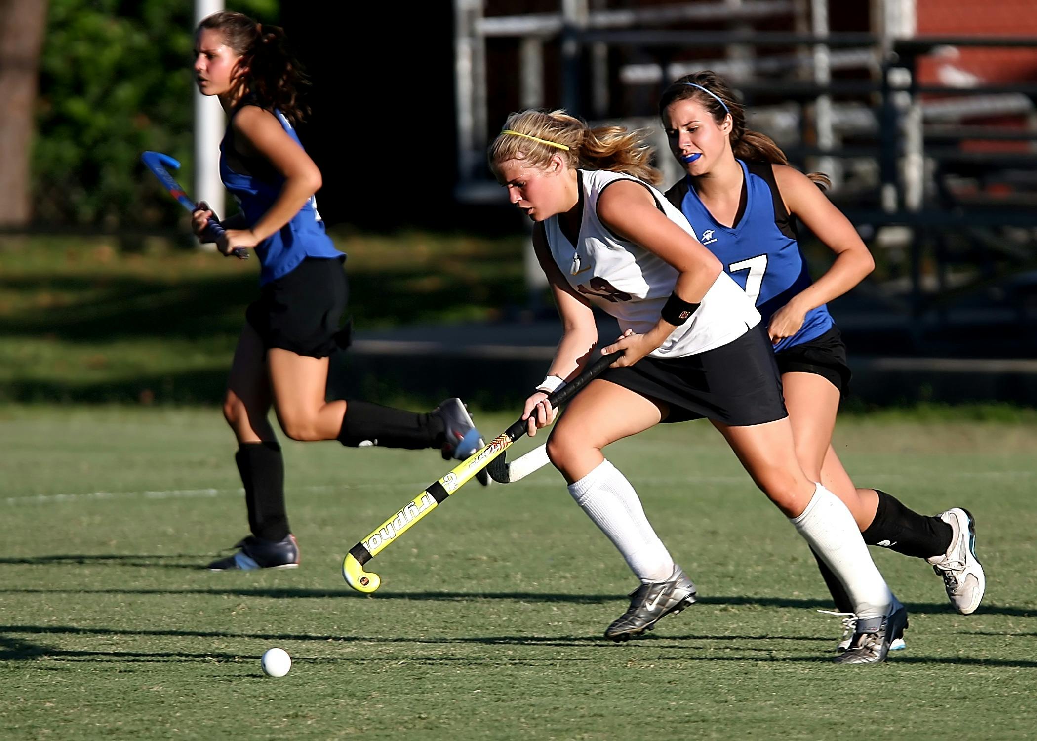 group of woman playing on green field during daytime