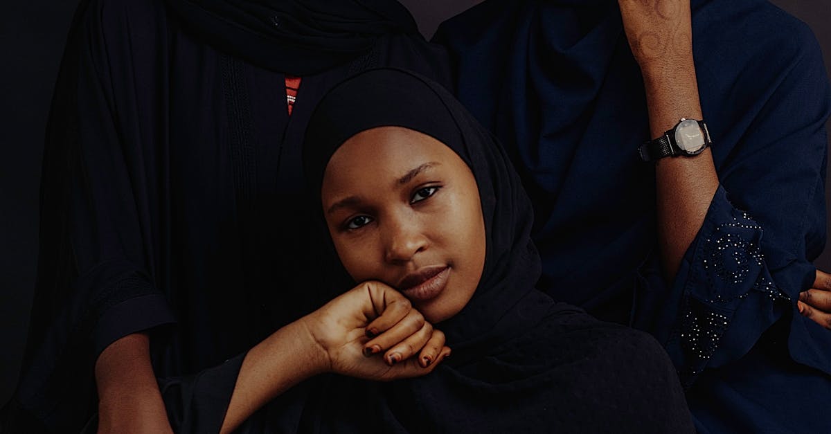 Three women in black clothing pose for a photo