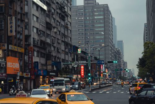 Free Bustling Taipei city street with taxis and skyscrapers, showcasing modern urban life. Stock Photo