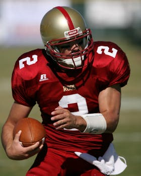 Dynamic shot of a football player in action on the field, ready to pass.