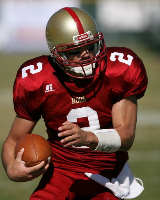 Dynamic shot of a football player in action on the field, ready to pass.