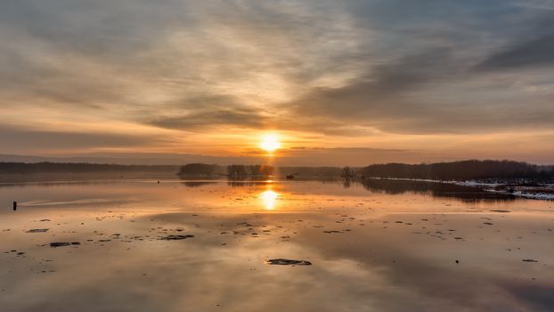 Captivating winter sunset over the Mississippi River at Reads Landing, Minnesota. Tranquil water reflection.