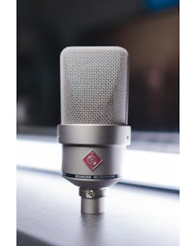 Close-up image of a Neumann microphone in a studio setting.