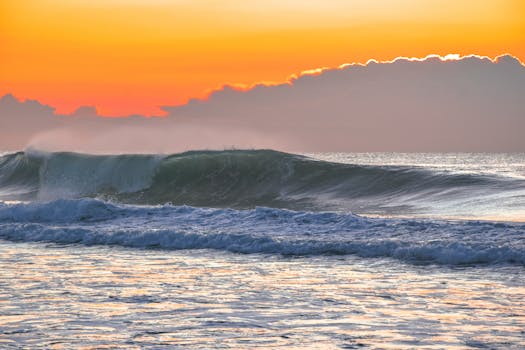 Peaceful seaside view with waves crashing under a stunning twilight sunset sky.