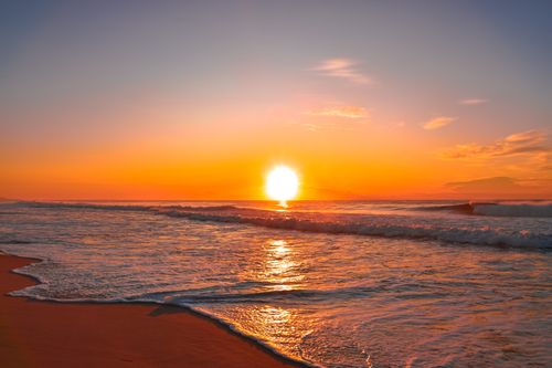 Free A breathtaking sunset over a calm ocean, perfect for serene landscape lovers. Stock Photo