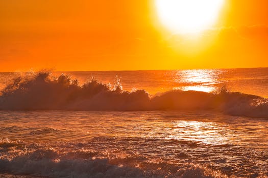 Vibrant sunset over ocean waves creating a serene and tranquil beach scene.