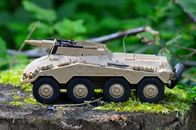 Tan Military Artillery Vehicle Toy on Wood Stump