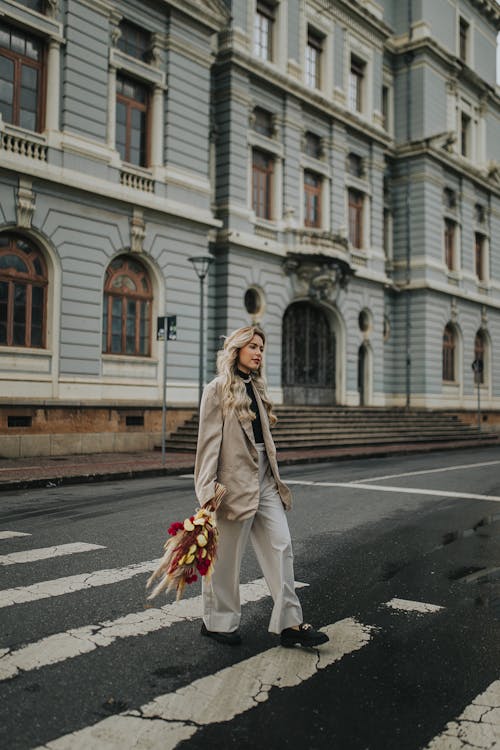 Young Fashionable Woman with a Bunch of Flowers Crossing the Street 