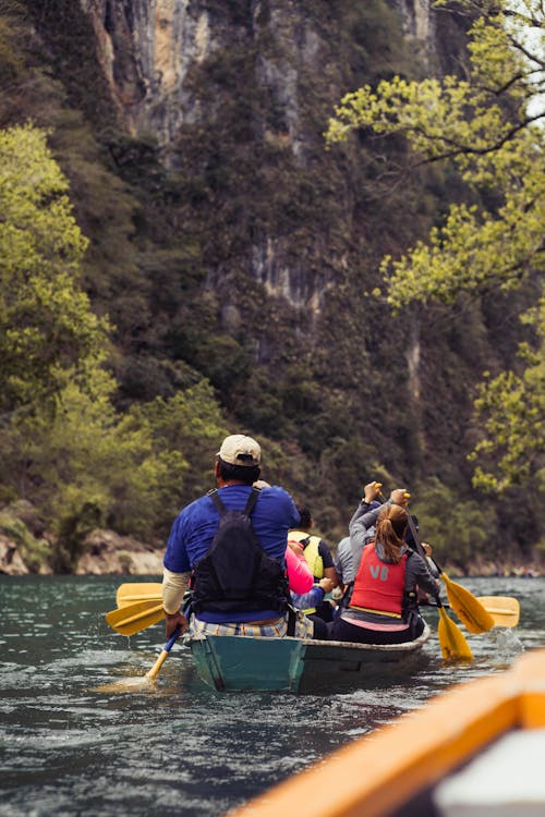 People Canoeing on a River in a Valley 