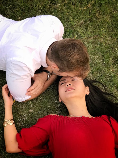 Free Woman and Man Lying on Grass Stock Photo