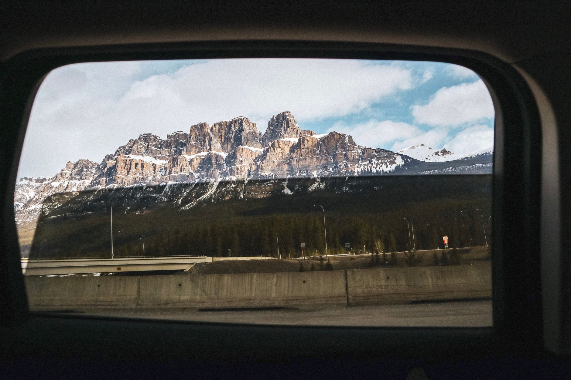 View of a rocky mountain highway seen through a vehicle window on a scenic drive