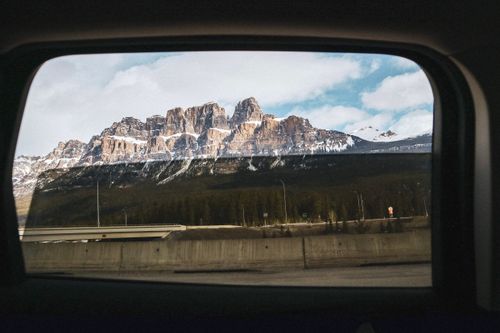 Free A breathtaking view of Castle Mountain in Banff National Park through a car window on a winter day. Stock Photo