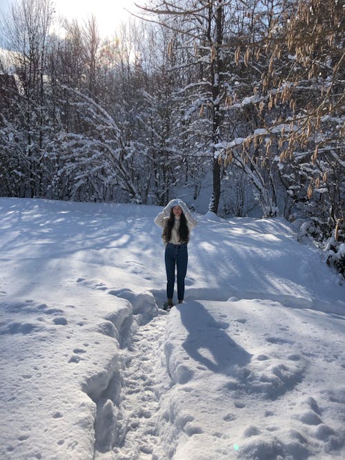 A Woman Standing on a Snowy Field 