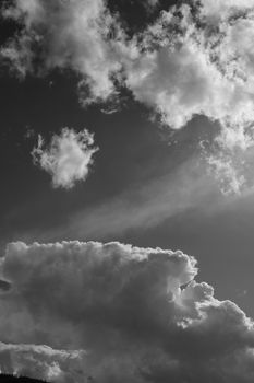 A striking black and white image of clouds with dramatic lighting and sunlight peeking through.