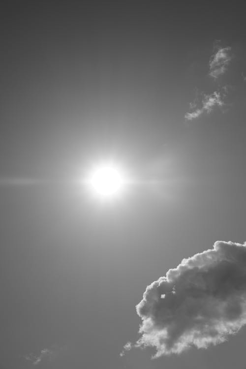 Black and White Picture of a Sky with Clouds and Sun 