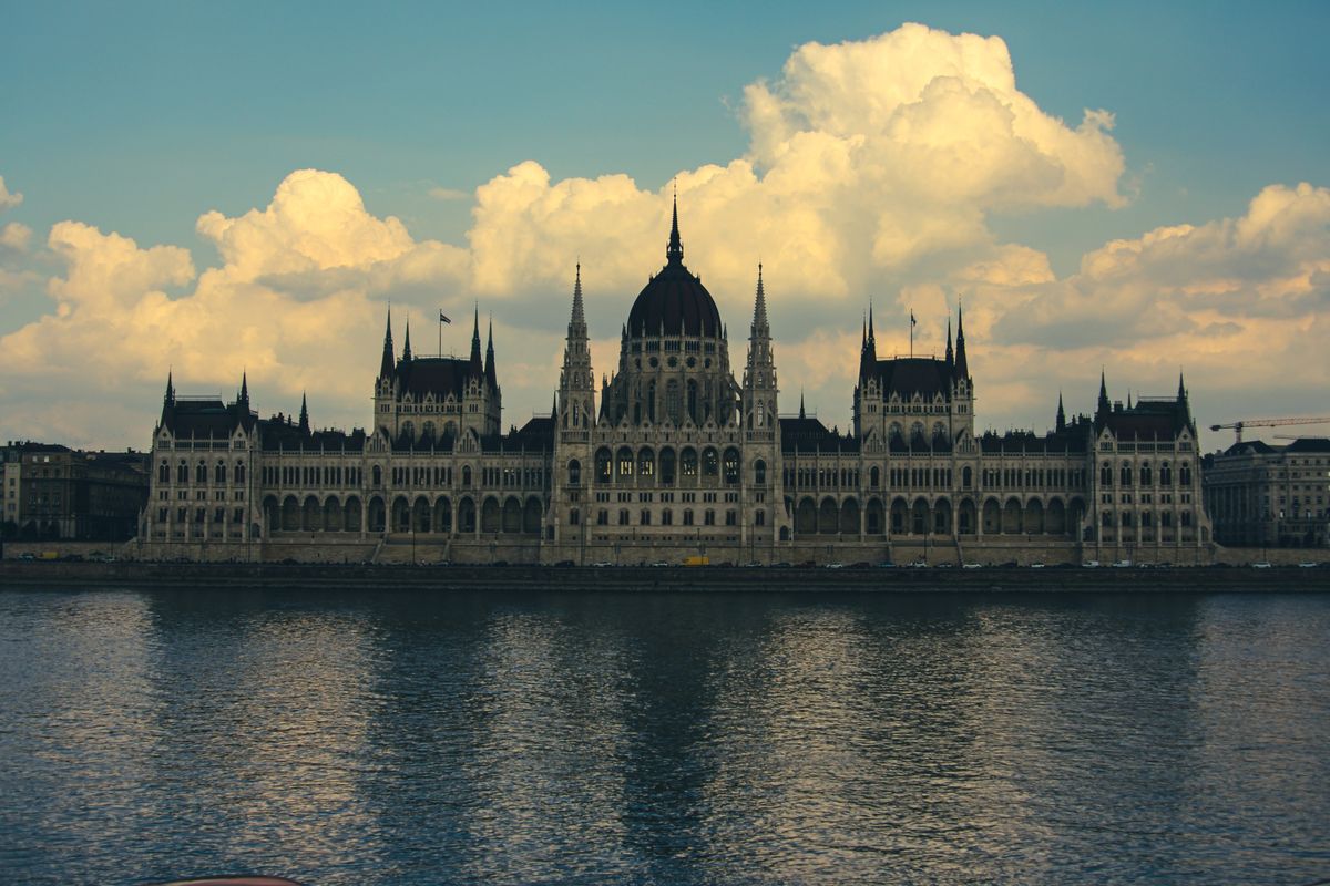 A breathtaking shot of the Hungarian Parliament Building reflecting on the Danube River in Budapest, capturing its grandeur.