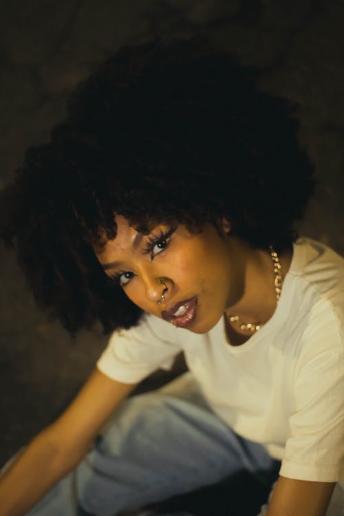 Free stock photo of black woman, city at night, curly hair