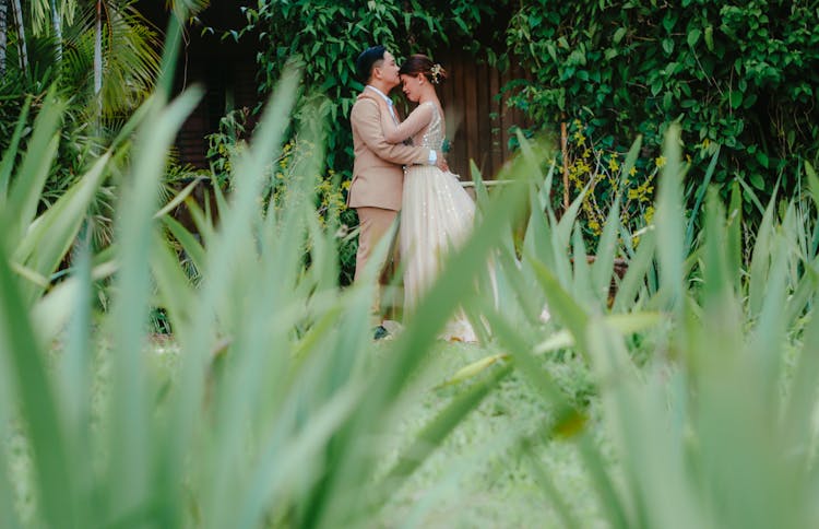 Hugging Newlyweds In Garden