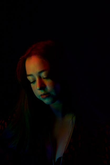 A woman with long hair in a dark room · Free Stock Photo