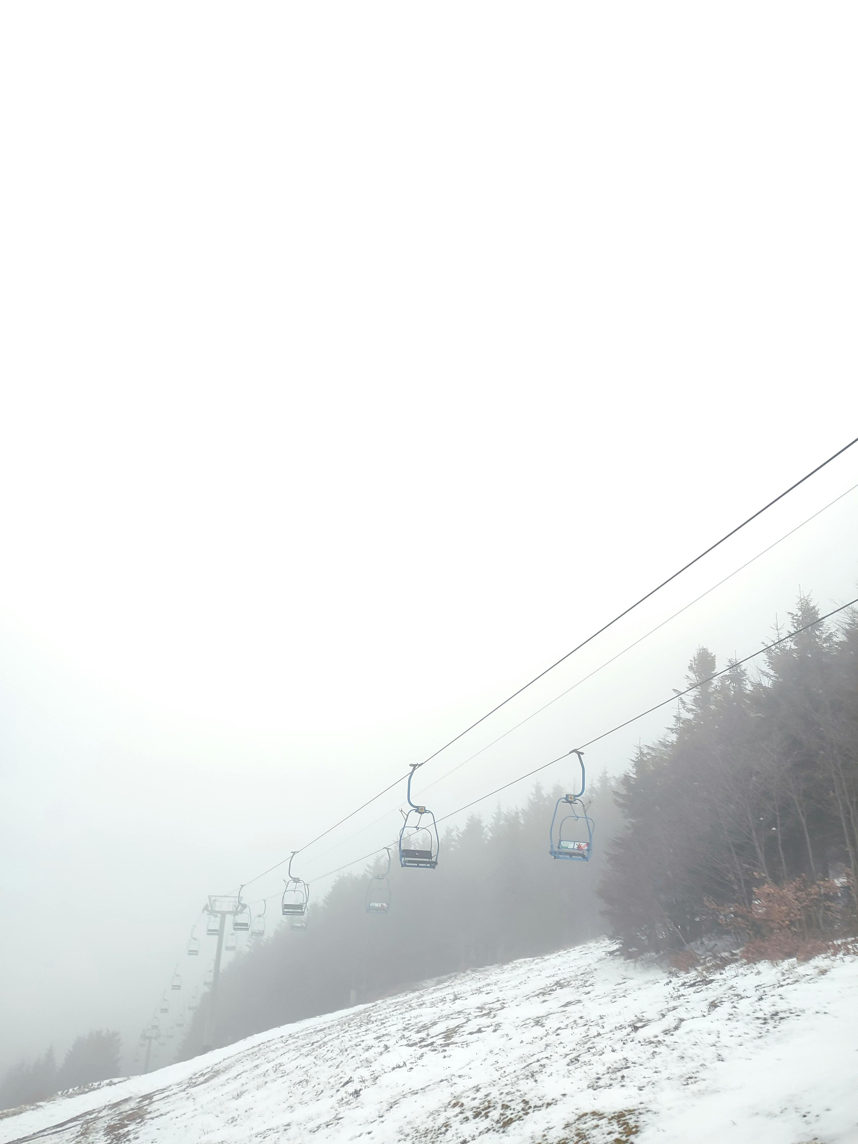 Prescription Goggle Inserts - Ski lifts ascend through fog on a snowy slope in Trojanovice, Czechia, capturing a serene winter scene.