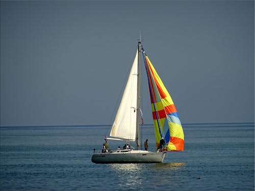 Barco A Vela Cinza E Branco Com 5 Pessoas Cavalgando No Meio Do Corpo D'água