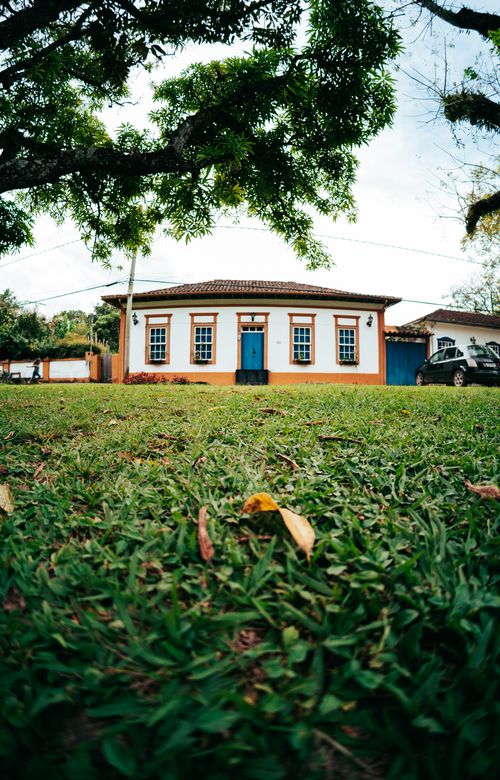 Free Colonial-style house in Tiradentes, Brazil with lush lawn and vibrant colors, ideal for travel and architecture themes. Stock Photo