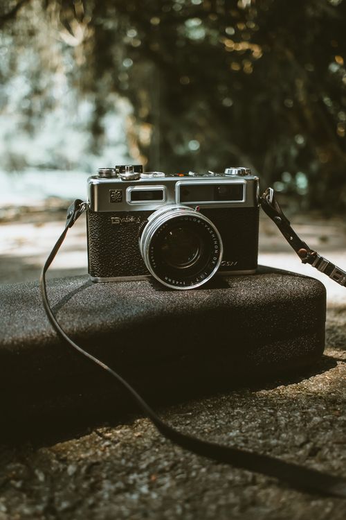 Free A classic vintage camera rests on a case outdoors, capturing nostalgia and retro vibes. Stock Photo