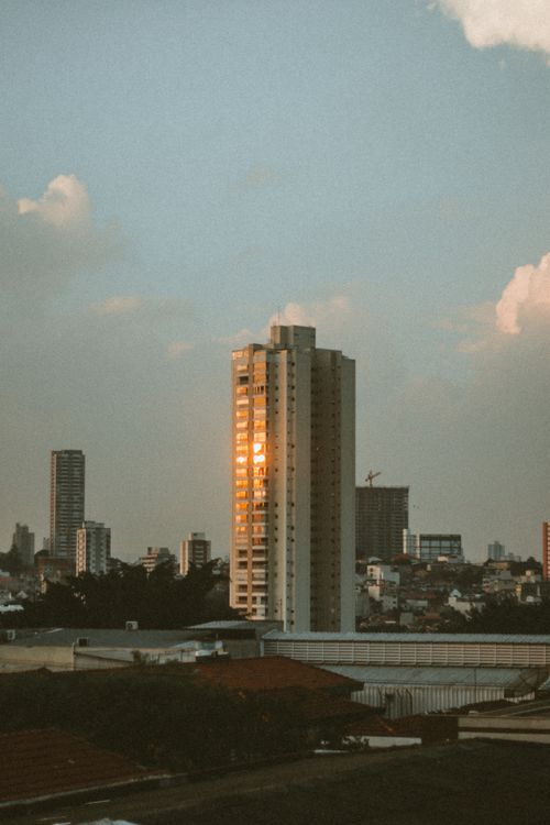 Free A city skyline with skyscrapers reflecting the warm glow of a sunset. Stock Photo