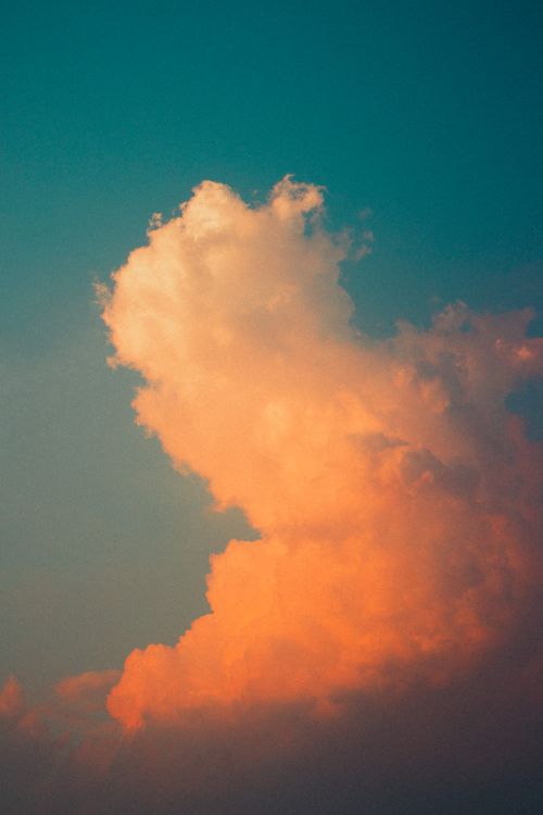 Free Captivating view of a cloud illuminated by sunset colors against a clear sky. Stock Photo
