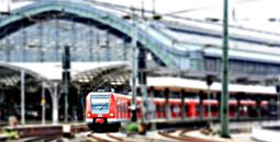 Red Train at a Green Train Station on an Overcast Day