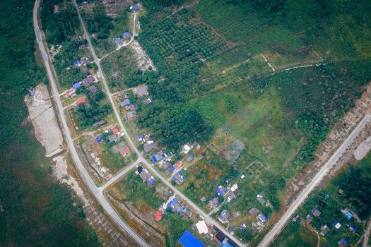 农村地区的无人机航拍景观中，有道路、房屋和绿地