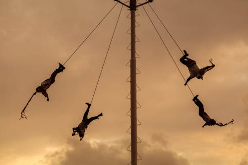 Acrobats Hanging on Pole